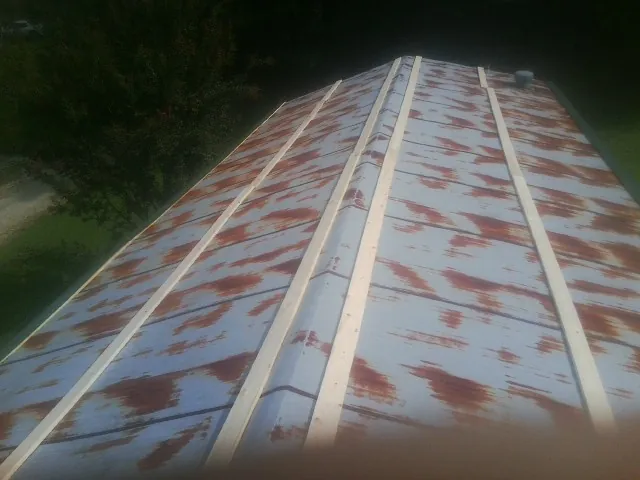 Rusted metal roof panels with new wood purlins before replacement — Storm Damage Roof Repair in West Haverstraw by Roofing Brothers